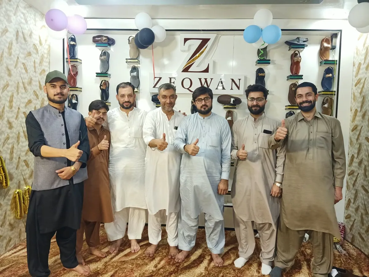 The Zeqwan team in front of the Zeqwan display wall in Peshawar